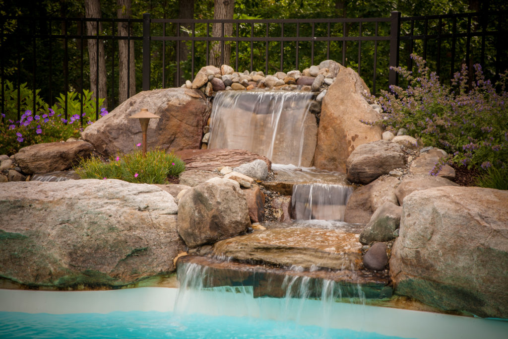 View of natural waterfall feature in pool. 